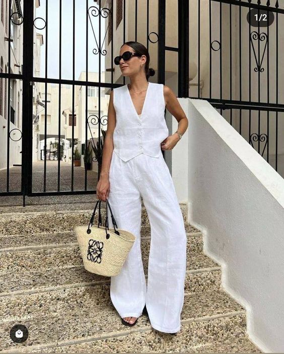 White jumpsuit complemented by a LOEWE straw bag